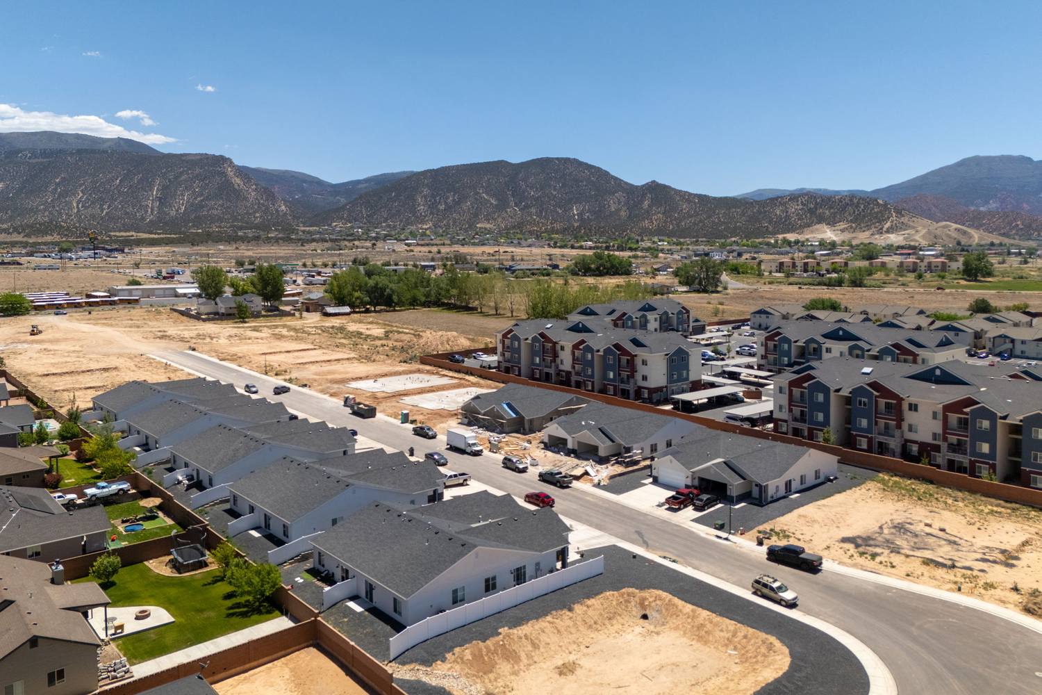 Aerial view over Old Farms toward the mountains, showing the new single-level homes and open farmland.