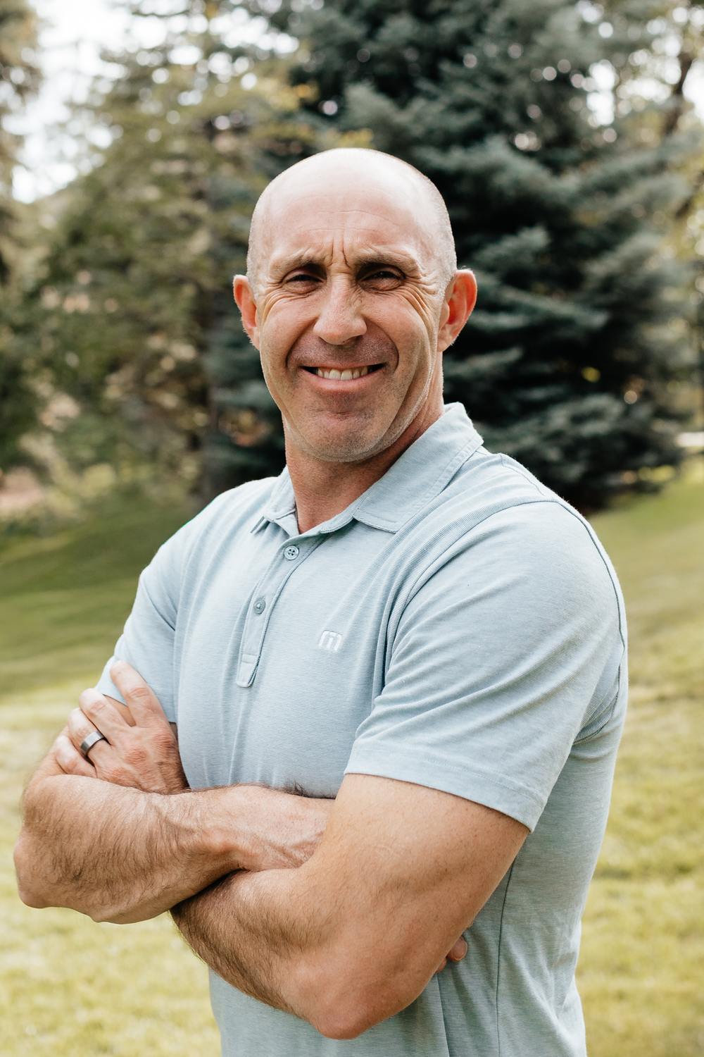 Michael Platt, owner of MHP Homes, standing outdoors with his arms folded.